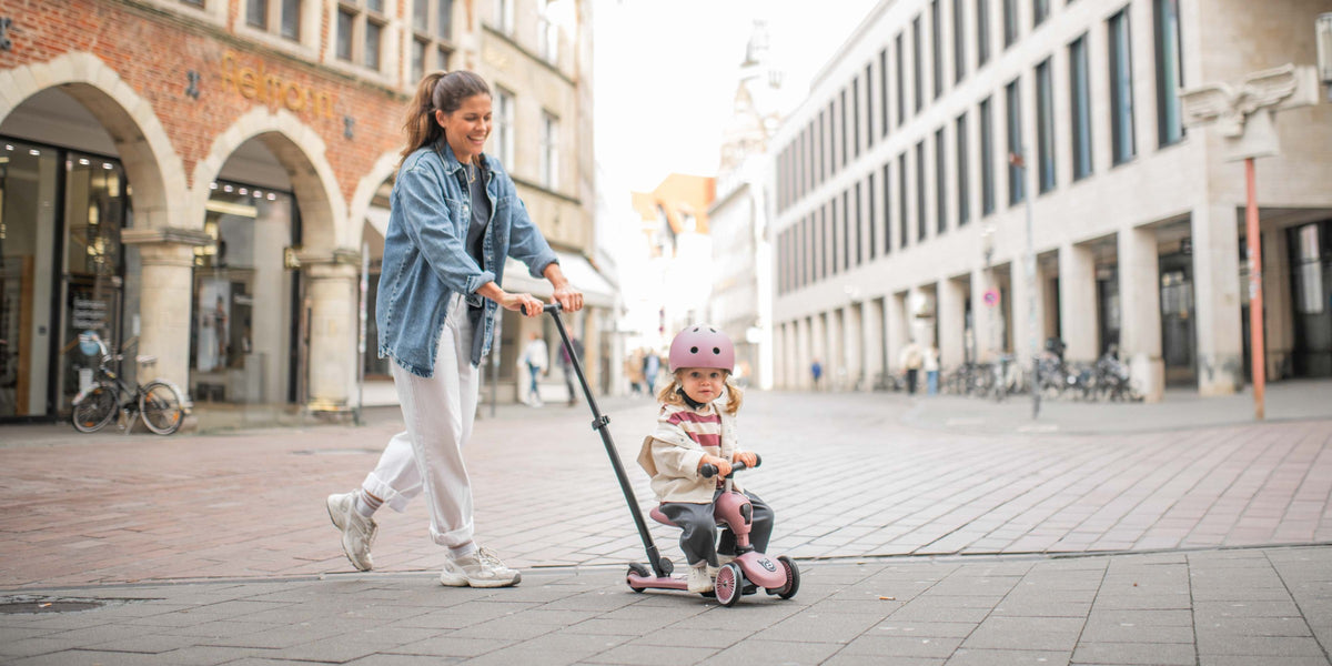 Mamma skyver jente på Highwaykick 1 Push & Go i Wildberry
